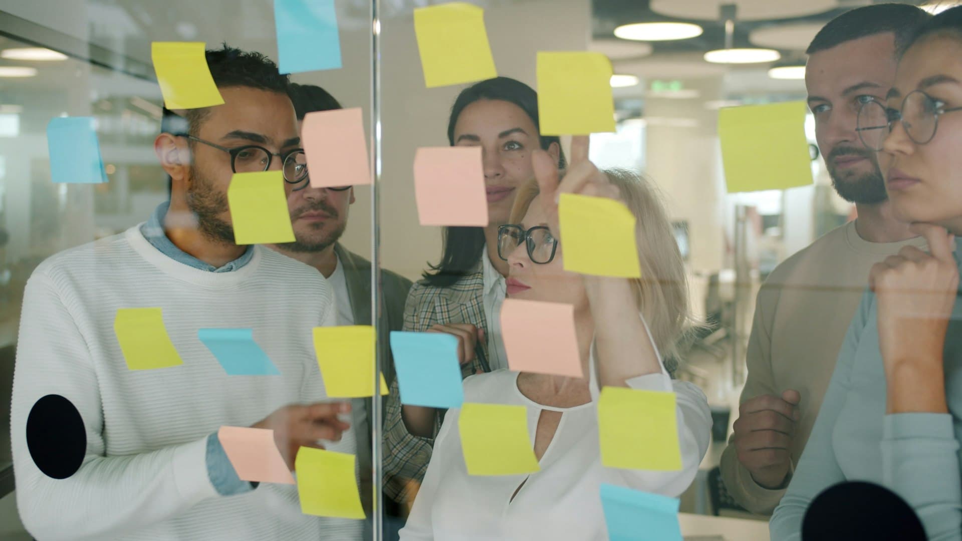 Diagnosis and operating-system planning session, sticky notes on a glass wall